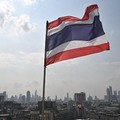 The Thai flag is seen with the city skyline the day after the general election, in Bangkok on February 9, 2026. (Photo by Lillian SUWANRUMPHA / AFP)
