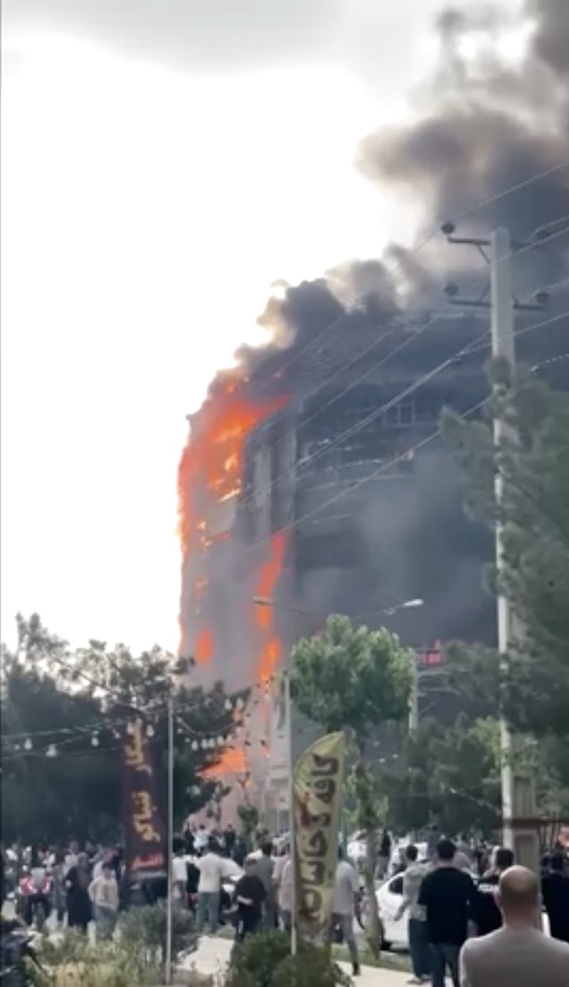 Flames and smoke rise after a fire broke out at a shopping center in Tehran, Iran, May 5, 2026, in this screen grab taken from social media video. SOCIAL MEDIA/via REUTERS  THIS IMAGE HAS BEEN SUPPLIED BY A THIRD PARTY. NO RESALES. NO ARCHIVES. NEWS USE ONLY.  Verification: - Buildings, utility poles, trees and road layout matched the archive and satellite imagery of the area - Coordinates:  35.70833490893601, 51.037304565984954 - Date verified from state news agency IRNA which reported the fire occurred on Tuesday - Several corroborating eyewitness videos uploaded on May 5 also showed fire at the same building