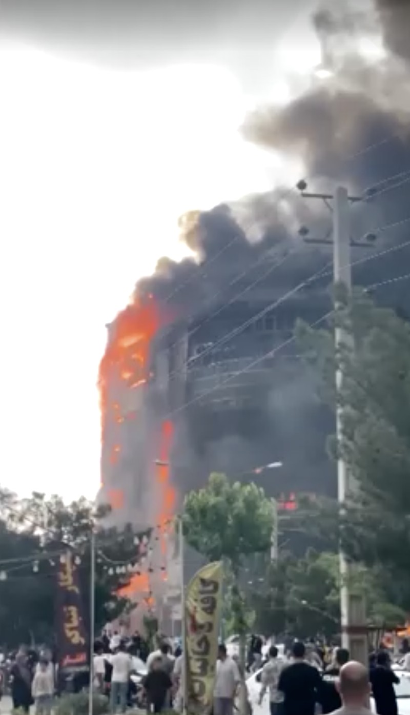 Flames and smoke rise after a fire broke out at a shopping center in Tehran, Iran, May 5, 2026, in this screen grab taken from social media video. SOCIAL MEDIA/via REUTERS  THIS IMAGE HAS BEEN SUPPLIED BY A THIRD PARTY. NO RESALES. NO ARCHIVES. NEWS USE ONLY.  Verification: - Buildings, utility poles, trees and road layout matched the archive and satellite imagery of the area - Coordinates:  35.70833490893601, 51.037304565984954 - Date verified from state news agency IRNA which reported the fire occurred on Tuesday - Several corroborating eyewitness videos uploaded on May 5 also showed fire at the same building