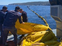 Para anggota Penjaga Pantai Yunani ikut serta dalam operasi pencegahan pencemaran laut, setelah sebuah kapal kargo kandas dan tenggelam di lepas pantai pulau Andros, Yunani, 6 Mei 2026. (Hellenic Coast Guard/Handout via REUTERS)