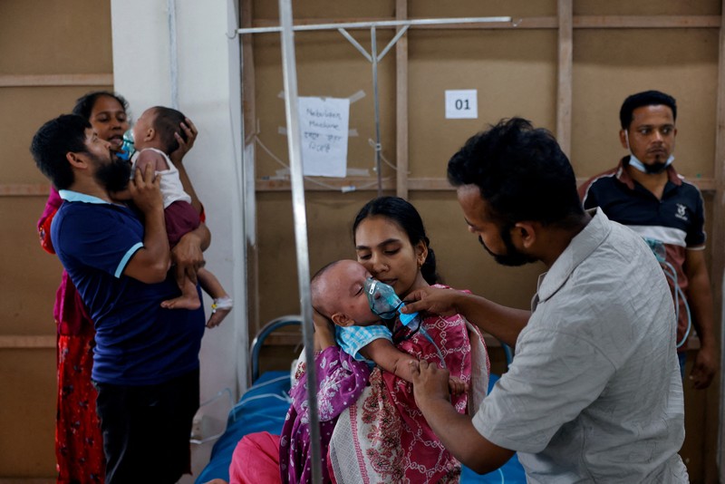 Para orang tua membantu anak-anak yang terinfeksi campak untuk menyesuaikan masker nebulizer mereka saat menerima perawatan di Rumah Sakit DNCC, menyusul wabah yang terjadi di seluruh negeri, di Dhaka, Bangladesh, 6 Mei 2026. (REUTERS/Mohammad Ponir  Hossain)