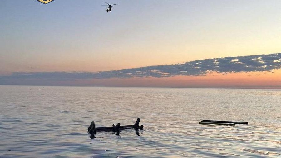 Sebuah pesawat terbang melintas selama operasi penyelamatan setelah sebuah kapal kargo kandas dan tenggelam di lepas pantai pulau Andros, Yunani, 6 Mei 2026.