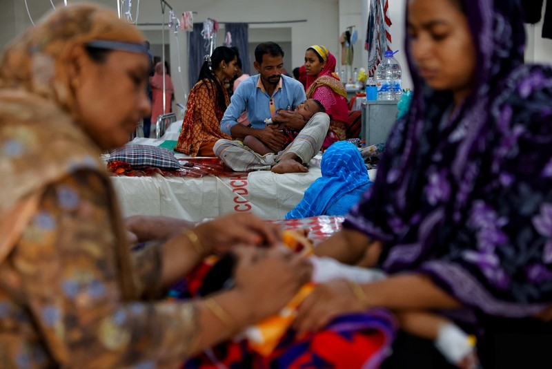 Para orang tua membantu anak-anak yang terinfeksi campak untuk menyesuaikan masker nebulizer mereka saat menerima perawatan di Rumah Sakit DNCC, menyusul wabah yang terjadi di seluruh negeri, di Dhaka, Bangladesh, 6 Mei 2026. (REUTERS/Mohammad Ponir  Hossain)
