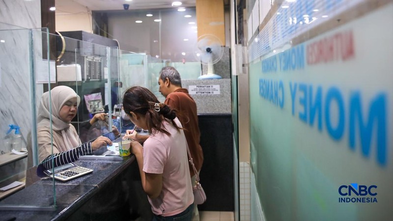 Warga melakukan penukaran mata uang rupiah ke dolar AS di Money Changer Valuta Artha Mas, Jakarta, Rabu (6/5/2026).