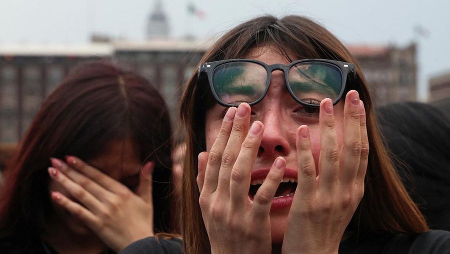 A girl reacts as fans of South Korean Kpop boy band BTS, known as ARMY, gather on the day members of the band meet with Mexico's President Claudia Sheinbaum at the National Palace ahead of a series of concerts on the BTS World Tour