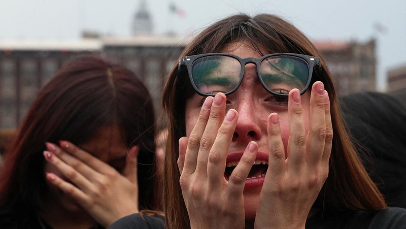 A girl reacts as fans of South Korean Kpop boy band BTS, known as ARMY, gather on the day members of the band meet with Mexico's President Claudia Sheinbaum at the National Palace ahead of a series of concerts on the BTS World Tour