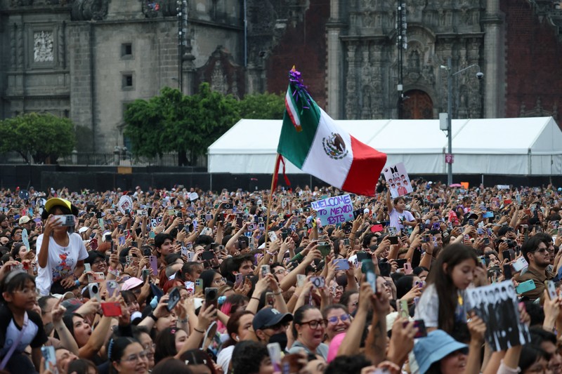Mexico's President Claudia Sheinbaum and members of South Korean Kpop boy band BTS react as they stand on a balcony of the National Palace ahead of a series of concerts on the BTS World Tour