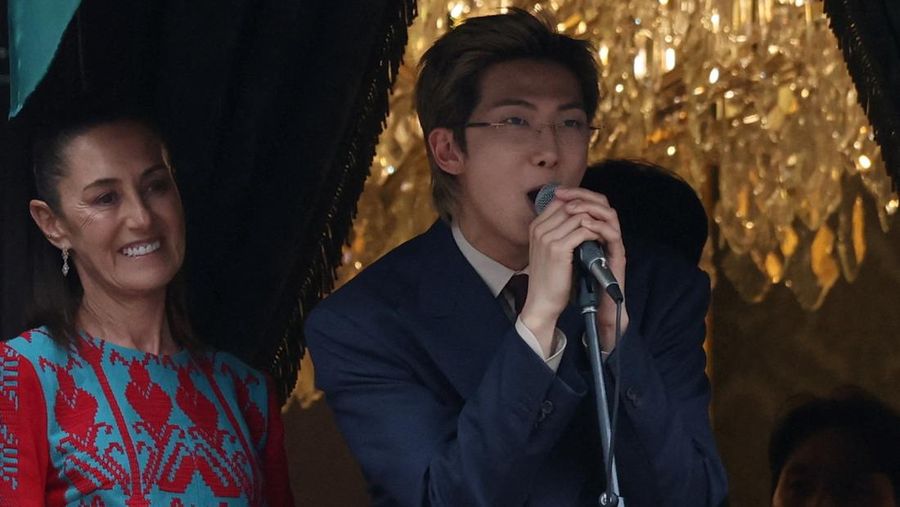 RM, of South Korean Kpop boy band BTS, speaks as Mexico's President Claudia Sheinbaum reacts on a balcony of the National Palace ahead of a series of concerts on the BTS World Tour
