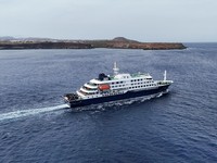 Pemandangan dari drone kapal pesiar MV Hondius, yang membawa penumpang yang diduga terinfeksi hantavirus, meninggalkan Praia, Tanjung Verde, 6 Mei 2026. (REUTERS/Stringer)