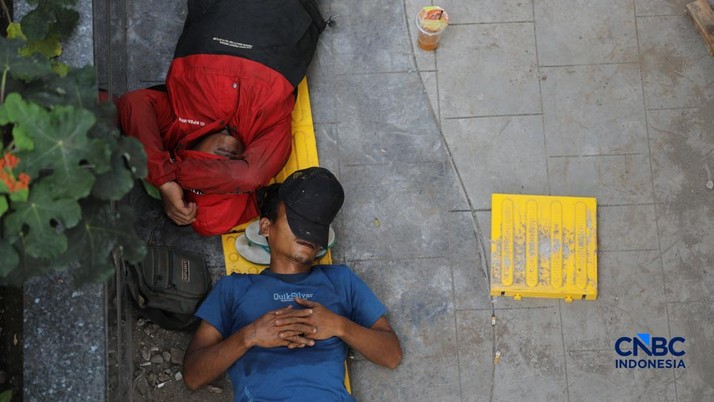 Sejumlah pekerja beristirahat di trotoar Jalan Rasuna Said, Jakarta, Kamis (7/5/2026). (CNBC Indonesia/Tri Susilo)