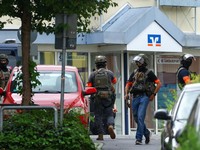 Anggota pasukan polisi khusus Jerman beroperasi di depan cabang bank tabungan di tengah respons terhadap situasi penyanderaan di kota Sinzig, dekat Bonn, di negara bagian Rhineland-Palatinate, Jerman, 8 Mei 2026. (REUTERS/Thilo Schmuelgen)