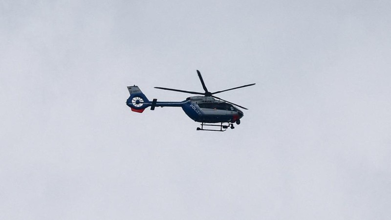 Sebuah helikopter polisi berpatroli di langit selama operasi menanggapi situasi penyanderaan di sebuah cabang bank tabungan di kota Sinzig, dekat Bonn, di negara bagian Rhineland-Palatinate, Jerman, 8 Mei 2026.