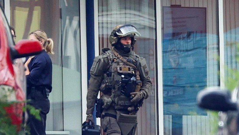 Seorang anggota pasukan polisi khusus Jerman beroperasi di depan cabang bank tabungan di tengah respons terhadap situasi penyanderaan di kota Sinzig, dekat Bonn, di negara bagian Rhineland-Palatinate, Jerman, 8 Mei 2026.