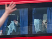 Passengers from the cruise ship MV Hondius affected by a hantavirus outbreak, gesture as they sit aboard a bus at the port of Granadilla de Abona, in Tenerife, Spain, May 10, 2026. REUTERS/Hannah McKay