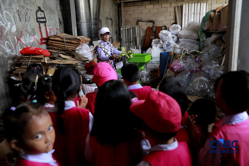 Pengelola Bank Sampah Rahmat memberikan edukasi pengelolaan sampah kepada siswa taman kanak-kanak (TK) di Bank Sampah Persatuan, Jalan Persatuan RW 08, Pondok Kelapa, Duren Sawit, Jakarta Timur, Senin (11/5/2026). (CNBC Indonesia/Muhammad Sabki)