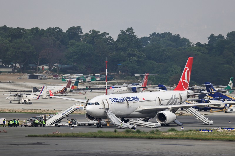 Pesawat milik Turkish Airlines mengalami insiden kebakaran pada ban roda pendaratan usai mendarat di Bandara Internasional Tribhuvan, Kathmandu, Nepal, Senin (11/5/2026) waktu setempat. Insiden itu memaksa otoritas bandara menghentikan sementara operasional penerbangan selama sekitar satu jam. (AFP/PRAKASH MATHEMA)