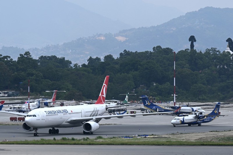 Pesawat milik Turkish Airlines mengalami insiden kebakaran pada ban roda pendaratan usai mendarat di Bandara Internasional Tribhuvan, Kathmandu, Nepal, Senin (11/5/2026) waktu setempat. Insiden itu memaksa otoritas bandara menghentikan sementara operasional penerbangan selama sekitar satu jam. (AFP/PRAKASH MATHEMA)