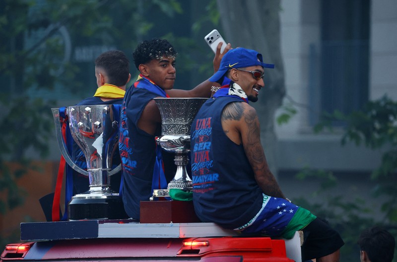 Para pemain FC Barcelona berada di atas bus parade saat merayakan keberhasilan menjuarai LaLiga di Barcelona, Senin (11/5/2026). (REUTERS/Albert Gea)