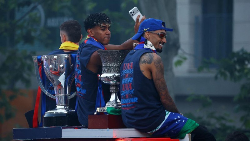 Lamine Yamal dan Raphinha mengikuti parade bus FC Barcelona untuk merayakan gelar LaLiga di Barcelona, Senin (11/5/2026).