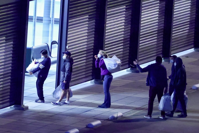 Personel berseragam hazmat berjalan di dekat pesawat yang membawa penumpang yang dievakuasi dari kapal pesiar MV Hondius, yang terkena wabah hantavirus, setelah mendarat di Pangkalan Udara Eindhoven di Eindhoven, Belanda, 12 Mei 2026. (REUTERS/Piroschka van de Wouw)