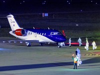 Personel berseragam hazmat berjalan di dekat pesawat yang membawa penumpang yang dievakuasi dari kapal pesiar MV Hondius, yang terkena wabah hantavirus, setelah mendarat di Pangkalan Udara Eindhoven di Eindhoven, Belanda, 12 Mei 2026. (REUTERS/Pirosc