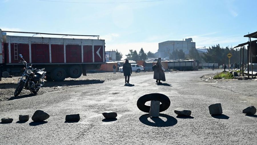 Seorang wanita berjalan melewati batu-batu yang menghalangi salah satu pintu masuk kota sambil menuntut pengunduran diri Presiden Rodrigo Paz di tengah krisis ekonomi dan bahan bakar yang sedang berlangsung, di El Alto, Bolivia, 11 Mei 2026.