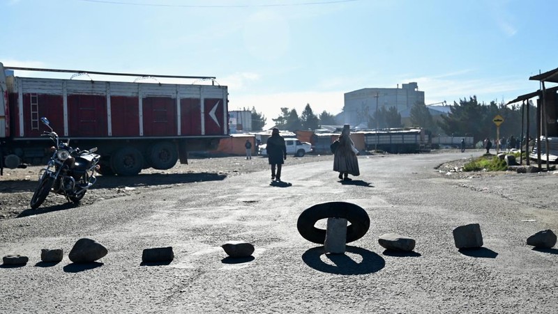 Seorang wanita berjalan melewati batu-batu yang menghalangi salah satu pintu masuk kota sambil menuntut pengunduran diri Presiden Rodrigo Paz di tengah krisis ekonomi dan bahan bakar yang sedang berlangsung, di El Alto, Bolivia, 11 Mei 2026.