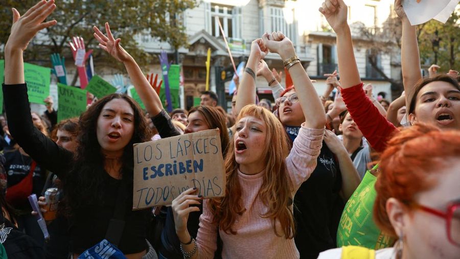 Seorang demonstran memegang papan bertuliskan