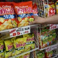 Seorang staf menambahkan stok keripik kentang Calbee ke rak di toko khusus permen di Tokyo, Jepang, 12 Mei 2026. (REUTERS/Issei Kato)