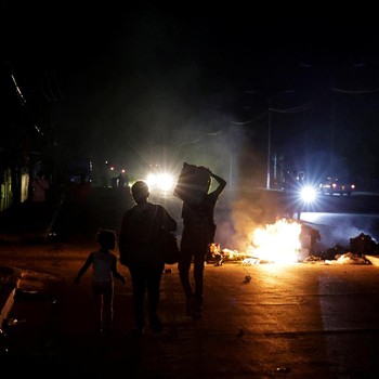 Orang-orang berjalan melewati sampah yang dibakar di tengah jalan selama protes terhadap pemadaman listrik yang sering terjadi saat Havana menghadapi pemadaman bergilir terburuk dalam beberapa dekade di tengah blokade AS yang telah mencekik pasokan b