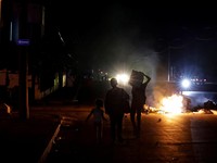 Orang-orang berjalan melewati sampah yang dibakar di tengah jalan selama protes terhadap pemadaman listrik yang sering terjadi saat Havana menghadapi pemadaman bergilir terburuk dalam beberapa dekade di tengah blokade AS yang telah mencekik pasokan b