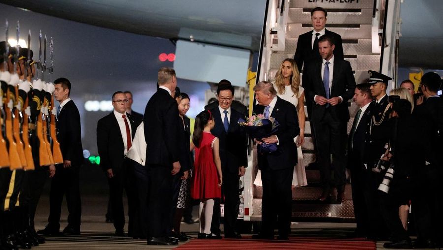 Presiden AS Donald Trump menerima karangan bunga, di samping Elon Musk, Eric Trump dan istrinya Lara, selama upacara kedatangan di Bandara Internasional Ibu Kota Beijing, di Beijing, China, 13 Mei 2026.