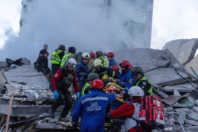 Para penyelamat membawa jenazah yang ditemukan dari bawah reruntuhan di lokasi gedung apartemen yang rusak akibat serangan rudal di Kyiv, Ukraina, Jumat (15/5/2026). (via REUTERS/STATE EMERGENCY SERVICE OF UKRAI)