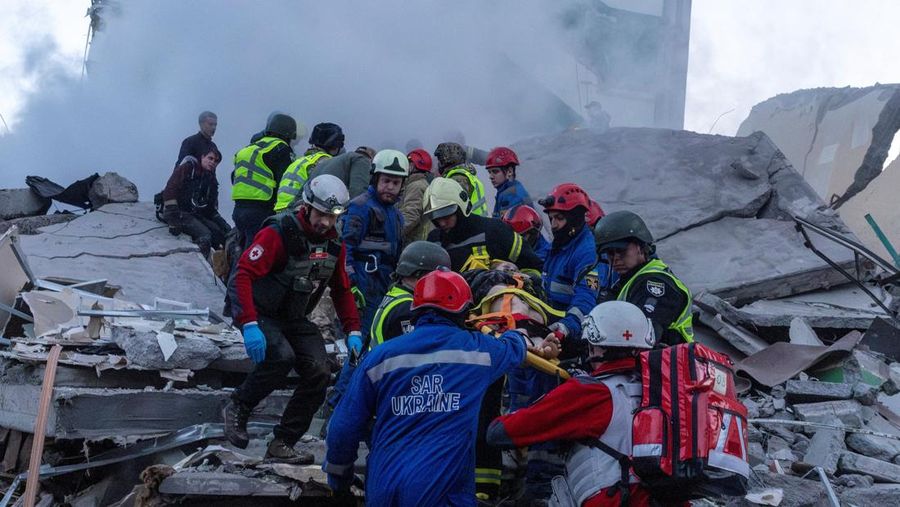 Para penyelamat membawa jenazah yang ditemukan dari bawah reruntuhan di lokasi gedung apartemen yang rusak akibat serangan rudal di Kyiv, Ukraina, Jumat (15/5/2026). (via REUTERS/STATE EMERGENCY SERVICE OF UKRAI)