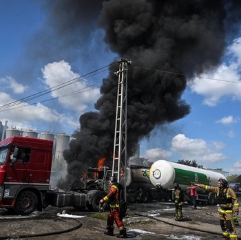 Petugas pemadam kebakaran bekerja di lokasi serangan pesawat tak berawak Rusia, di tengah serangan Rusia terhadap Ukraina, di Zaporizhzhia, Ukraina, Jumat (15/5/2026). (REUTERS/Stringer)