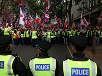 Para petugas polisi berjaga-jaga saat para pengunjuk rasa berkumpul pada hari unjuk rasa "Satukan Kerajaan".