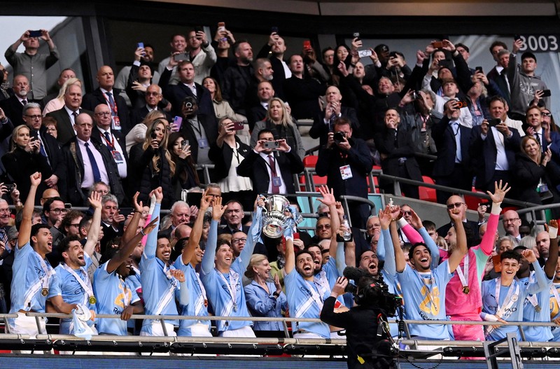 Para pemain dan staf Manchester City merayakan kemenangan dengan trofi Piala FA usai final melawan Chelsea FC di Stadion Wembley, Sabtu (16/5/2026). (Images via Reuters/Peter Cziborra)