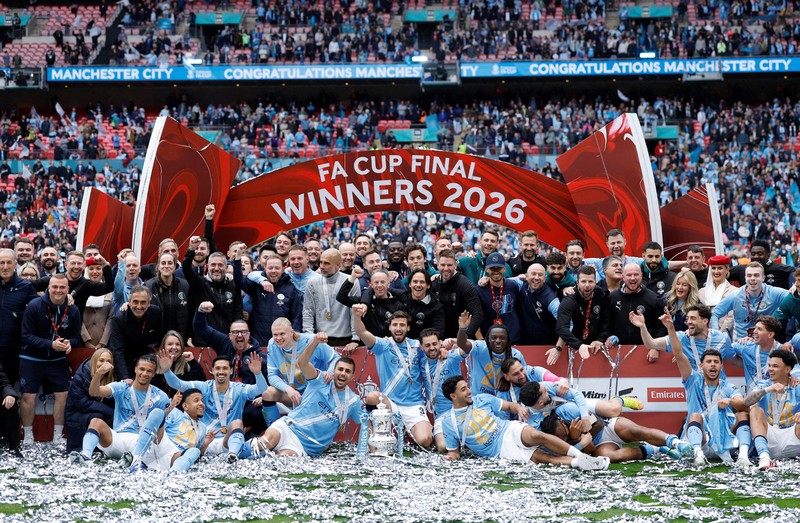 Para pemain dan staf Manchester City merayakan kemenangan dengan trofi Piala FA usai final melawan Chelsea FC di Stadion Wembley, Sabtu (16/5/2026). (Images via Reuters/Peter Cziborra)