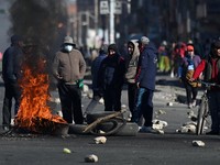 Para pengunjuk rasa berdiri di samping ban yang terbakar saat mereka berdemonstrasi menentang pemerintahan Presiden Rodrigo Paz di tengah krisis ekonomi dan bahan bakar yang sedang berlangsung, di El Alto, Bolivia, 16 Mei 2026. (REUTERS/Claudia Moral