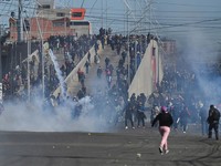 Para pengunjuk rasa berlari melewati gas air mata saat mereka berdemonstrasi menentang pemerintahan Presiden Rodrigo Paz di tengah krisis ekonomi dan bahan bakar yang sedang berlangsung di El Alto, Bolivia, 16 Mei 2026. (REUTERS/Claudia Morales)