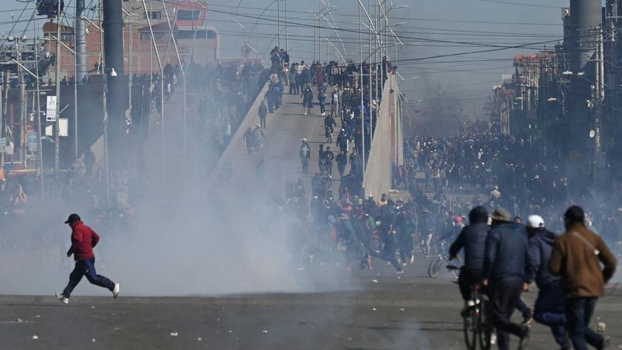 Para pengunjuk rasa berlari melewati gas air mata saat mereka berdemonstrasi menentang pemerintahan Presiden Rodrigo Paz di tengah krisis ekonomi dan bahan bakar yang sedang berlangsung di El Alto, Bolivia, 16 Mei 2026.