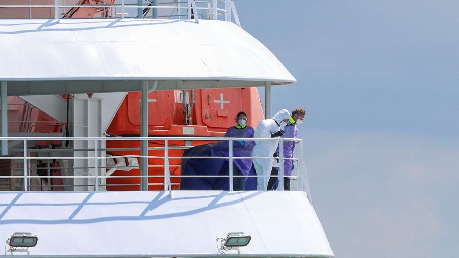 Orang-orang yang mengenakan pakaian pelindung diri di atas kapal pesiar MV Hondius, yang terkena wabah hantavirus, setelah tiba di Pelabuhan Rotterdam, tempat otoritas Belanda sedang mempersiapkan pengaturan karantina, di Rotterdam, Belanda, 18 Mei 2026.