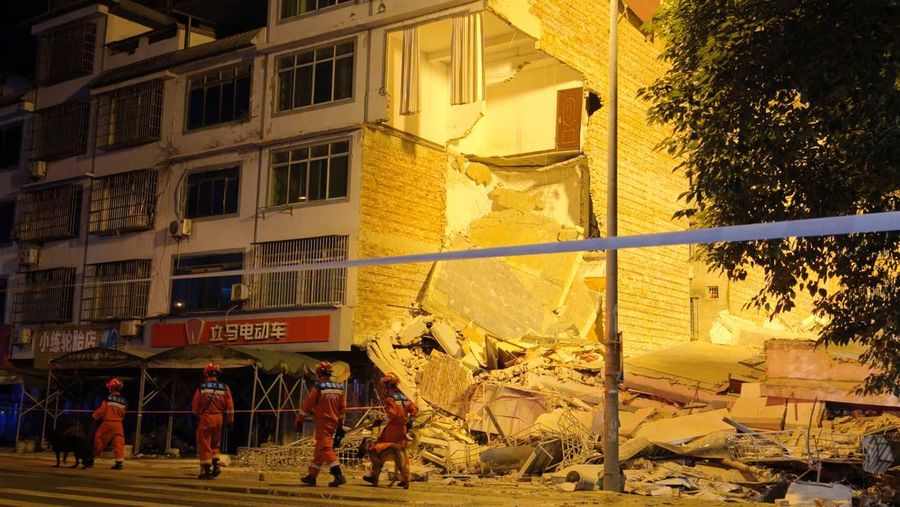 Petugas penyelamat berjalan melewati bangunan yang rusak akibat gempa bumi di desa Taiyang, Liuzhou, Daerah Otonomi Guangxi Zhuang, China, Senin (18/5/2026). (cnsphoto via REUTERS)
