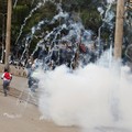 Orang-orang berlarian saat petugas polisi menggunakan gas air mata untuk membubarkan demonstran selama pemogokan operator transportasi umum yang dipicu oleh kenaikan biaya bahan bakar terkait dengan tekanan pasokan global akibat perang di Iran, di pu