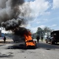 Petugas polisi anti huru hara berjalan untuk membersihkan barikade yang didirikan oleh para pengunjuk rasa selama pemogokan operator transportasi umum yang dipicu oleh kenaikan biaya bahan bakar terkait dengan tekanan pasokan global, di kota Nakuru,