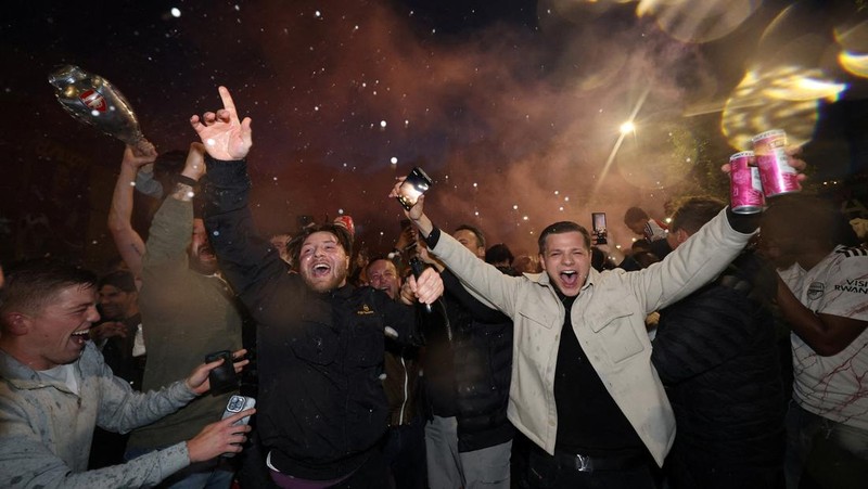 Para penggemar Arsenal merayakan kemenangan di luar stadion Emirates saat Arsenal memenangkan Liga Inggris di London, Inggris, Selasa (19/4/2026) malam waktu setempat. (Action Images via Reuters/Andrew Boyers)