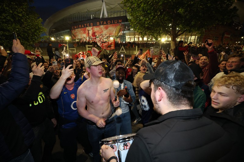 Para penggemar Arsenal merayakan kemenangan di luar stadion Emirates saat Arsenal memenangkan Liga Inggris di London, Inggris, Selasa (19/4/2026) malam waktu setempat. (Action Images via Reuters/Andrew Boyers)