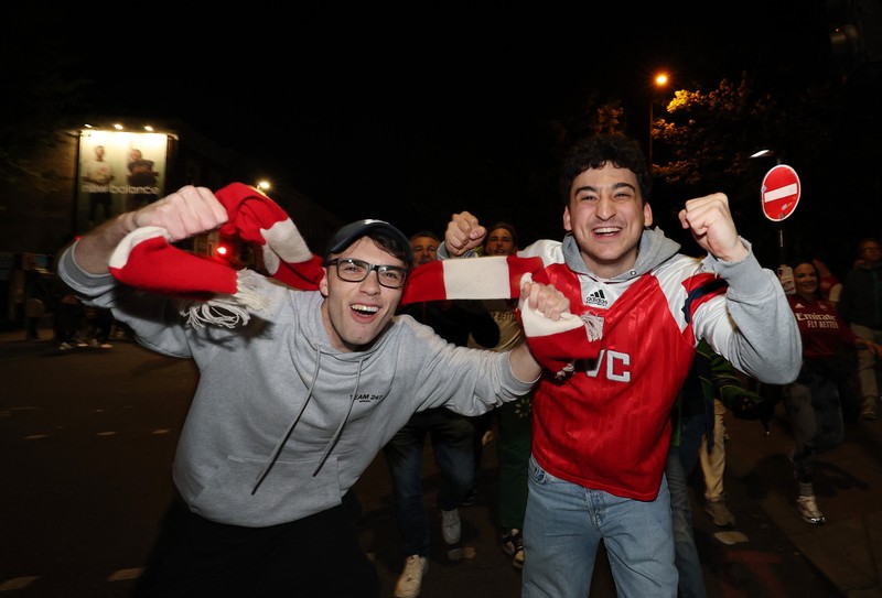 Para penggemar Arsenal merayakan kemenangan di luar stadion Emirates saat Arsenal memenangkan Liga Inggris di London, Inggris, Selasa (19/4/2026) malam waktu setempat. (Action Images via Reuters/Andrew Boyers)