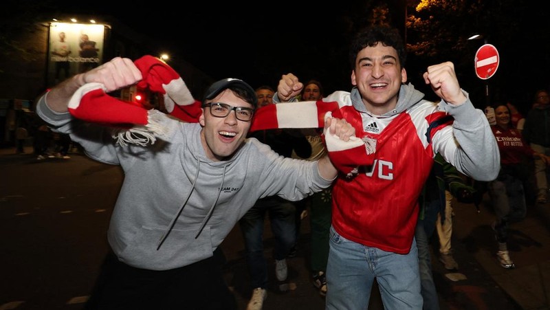Para penggemar Arsenal merayakan kemenangan di luar stadion Emirates saat Arsenal memenangkan Liga Inggris di London, Inggris, Selasa (19/4/2026) malam waktu setempat. (Action Images via Reuters/Andrew Boyers)