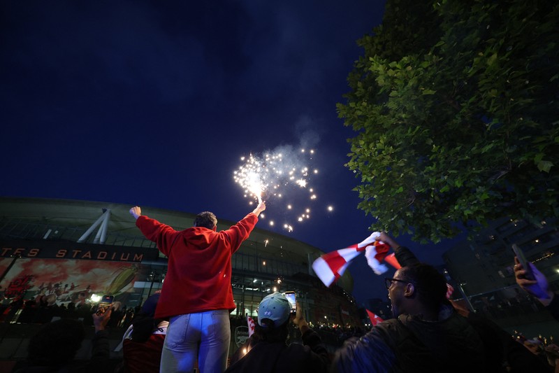 Para penggemar Arsenal merayakan kemenangan di luar stadion Emirates saat Arsenal memenangkan Liga Inggris di London, Inggris, Selasa (19/4/2026) malam waktu setempat. (Action Images via Reuters/Andrew Boyers)